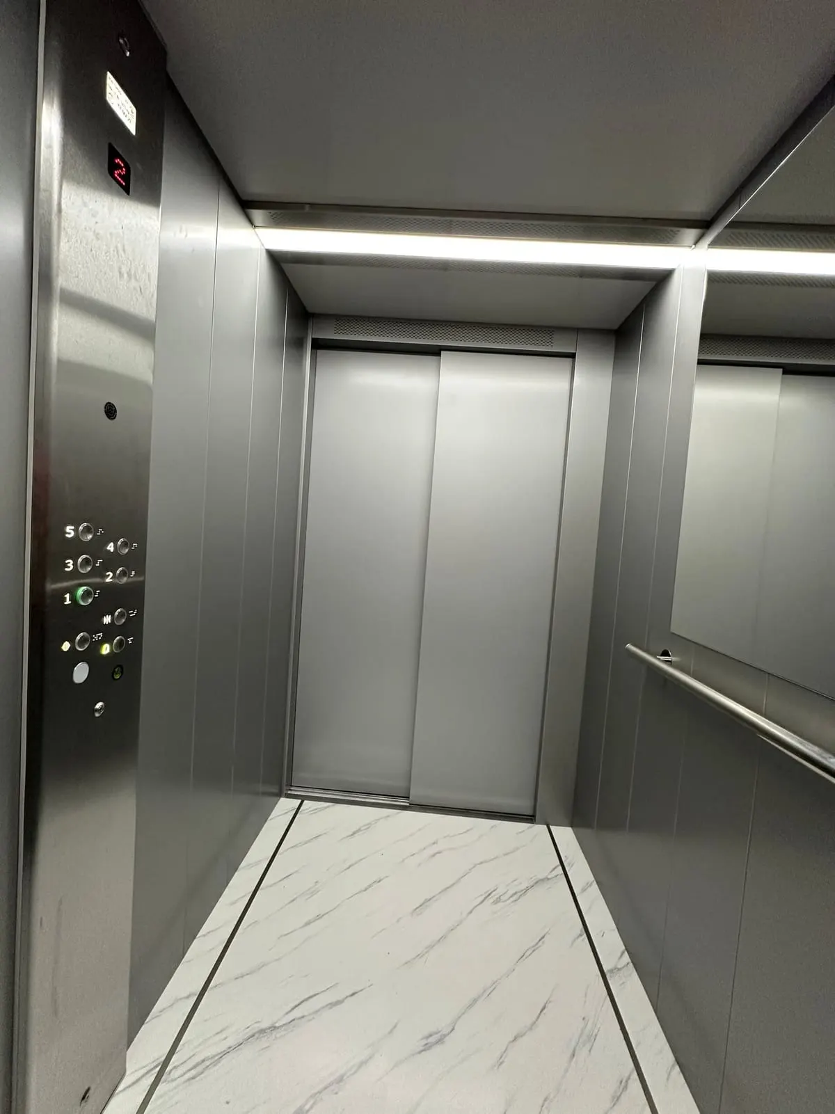 Панель наказів на всю висоту кабіни ліфта з кнопками поверхів і цифровим індикатором